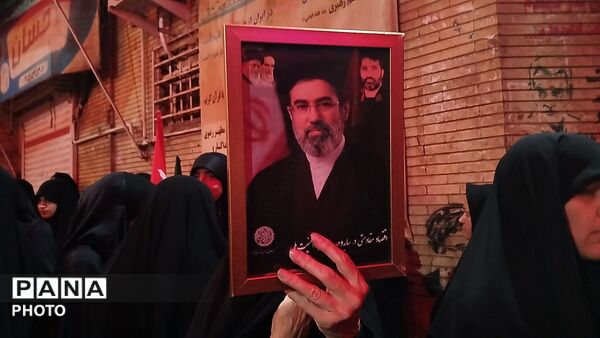 نگاهی به سیمای نورانی رهبر شهید در دست مردم