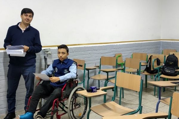 دانش آموز خبرنگار خبرگزاری پانا نشسته بر صندلی چرخدار در پای آزمون نوبت اول