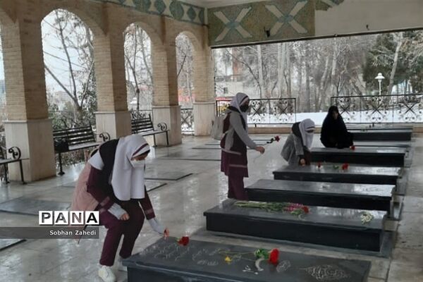 غبارروبی مزارشهدا توسط دانش‌آموزان رودهن در دهه فجر