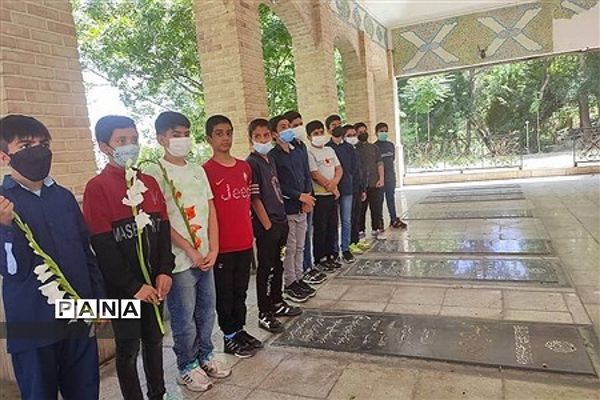 غبارروبی مزار شهدا توسط دانش‌آموزان رودهن در هفته بسیج