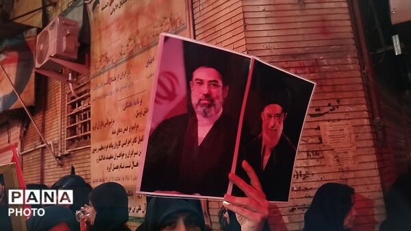 نگاهی به سیمای نورانی رهبر شهید در دست مردم